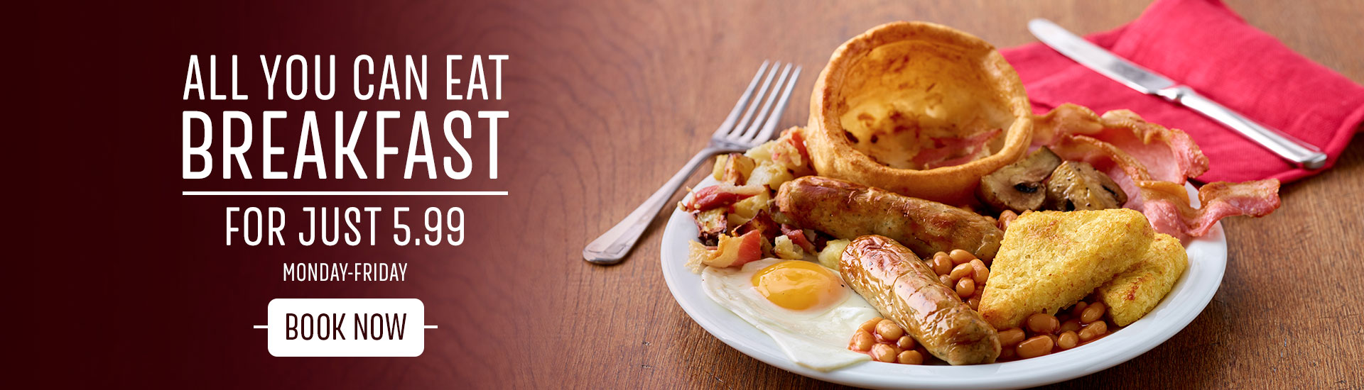 A close-up photograph of a Toby Carvery breakfast, with breakfast Yorkshire pudding, hash browns, mushrooms, egg, sausage and beans
